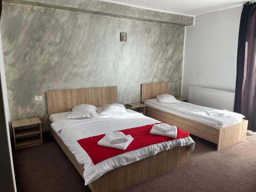a bedroom with two beds with towels on them at Pensiune Stirbu in Borsa