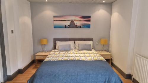 a bedroom with a blue bed and two lamps at The Geo Apartment in Montrose