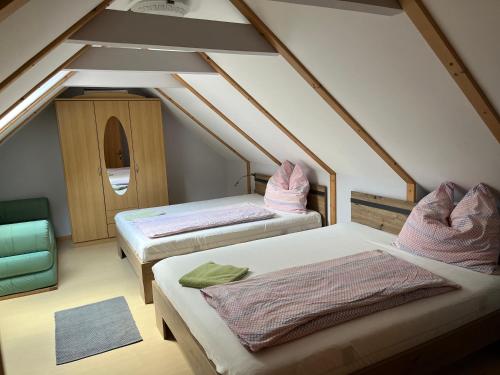 a attic room with two beds and a window at Ferienhaus Stolz in Sankt Peter am Kammersberg