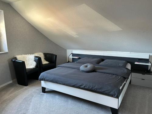 a bedroom with a large bed and a chair at wunderschöne "Ferienwohnung-Simmerath de" Eifel NordEifel Nationalpark in Simmerath