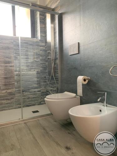 a bathroom with a toilet and a sink and a shower at Casa Alba in Taranto