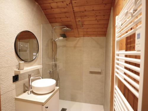 a bathroom with a sink and a shower with a mirror at Chalet Olive in Durbuy