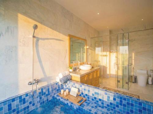 a bathroom with a tub and a shower and a sink at Entire Hoi An Villas By Ovui in Hoi An