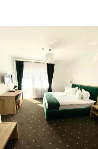 a hotel room with a large bed and a window at Paunasul Codrilor in Câmpulung Moldovenesc