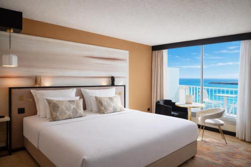 a bedroom with a large bed and a large window at Hotel Ker Moor Saint-Quay Portrieux in Saint-Quay-Portrieux