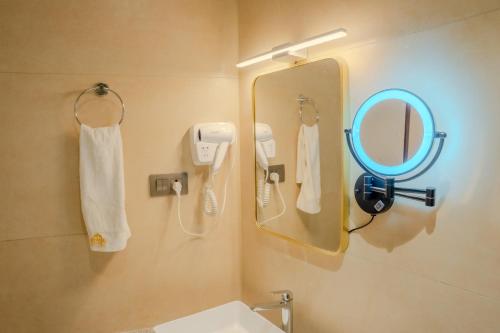 a bathroom with a mirror and a sink at Hotel Smart Durbar in Dharampur