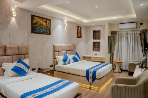 a hotel room with two beds and a television at Hotel Smart Durbar in Dharampur