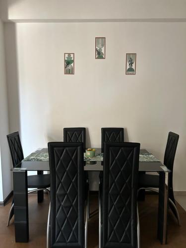 a dining room with black tables and black chairs at Mirror Apartments in Petrovec