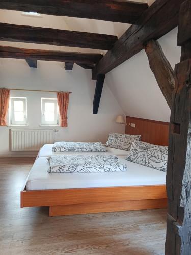a bedroom with a large bed in the attic at Pension Webstuhl in Deizisau