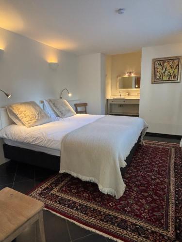 a bedroom with a large white bed with a rug at BelleVie Apartment, Eijsden-Maastricht in Eijsden