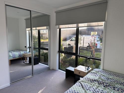 a bedroom with a bed and large glass windows at The elite Home in Rockbank