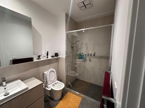 a bathroom with a toilet and a sink and a shower at The elite Home in Rockbank