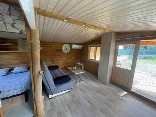 a bedroom in a log cabin with a bed and a table at Chalet LALi in Saint-Étienne-de-Fontbellon