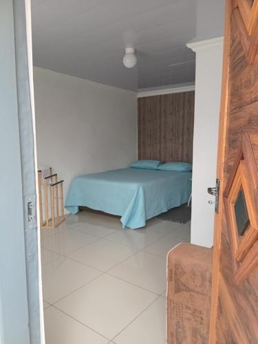 a bedroom with a bed with blue pillows in it at Mamela BNB in Elandsfontein