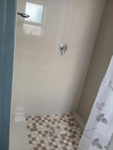 a shower with a checkered floor in a bathroom at Mamela BNB in Elandsfontein