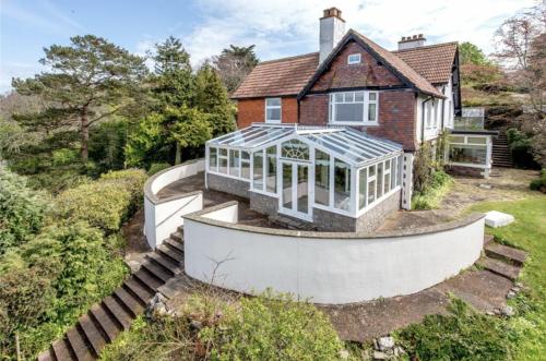 an exterior view of a house with a greenhouse at Bay View Porlock Bed & Breakfast in Porlock