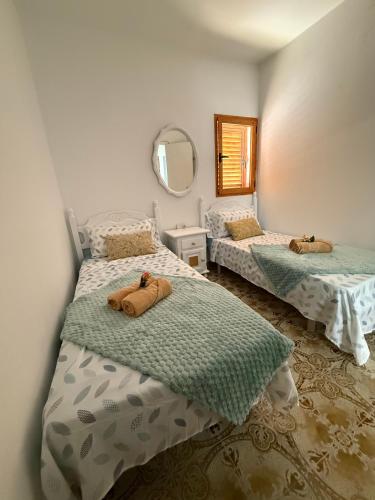 a bedroom with two beds and a mirror at Nature in Tejeda 2 in Tejeda