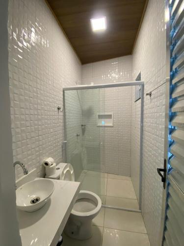 a bathroom with a shower and a toilet and a sink at Pousada da Mangueira 1 in Barreirinhas