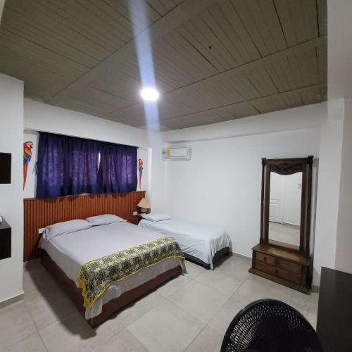 a bedroom with a bed and a mirror in it at Hostal Casa Marle in Puerto Colombia