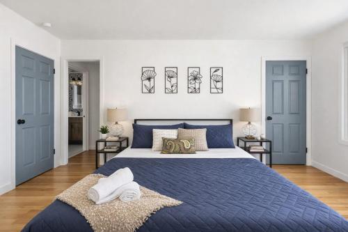 a bedroom with a blue bed and two doors at Fire pit ~ Game Room ~ near NYC ~ Modern Luxury in New Rochelle