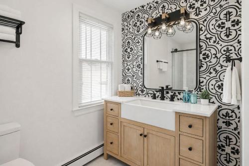 a bathroom with a sink and a mirror at Fire pit ~ Game Room ~ near NYC ~ Modern Luxury in New Rochelle