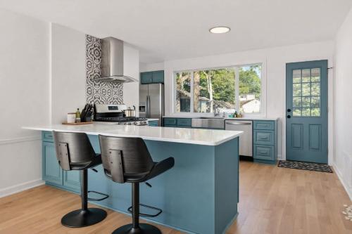 a kitchen with a blue island with two bar stools at Fire pit ~ Game Room ~ near NYC ~ Modern Luxury in New Rochelle