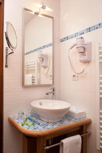 a bathroom with a sink and a mirror at Hôtel la Croix Blanche in Le Mont Saint Michel