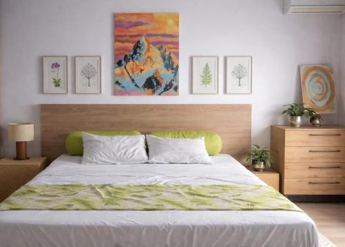 a bedroom with a large bed and paintings on the wall at Skyra Villa in Mahébourg