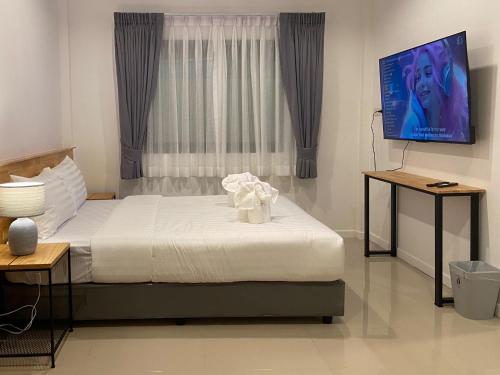 a bedroom with a bed and a flat screen tv at B House Phuket in Chalong