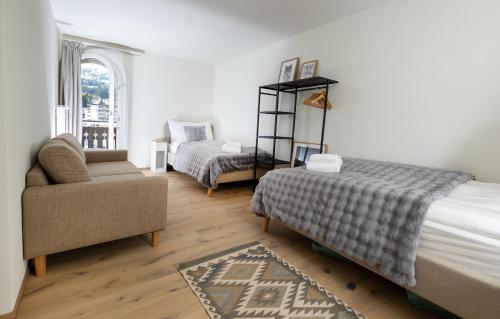 a bedroom with a bed and a couch and a chair at 5 room apartment for 8 people at Bergcafe Aurora Lenzerheide in Lenzerheide