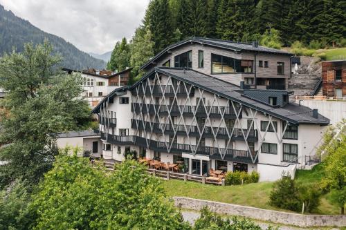 ein großes weißes Gebäude an einem Berghang in der Unterkunft ARPURIA - 4 Star Superior - Adults Only in Sankt Anton am Arlberg