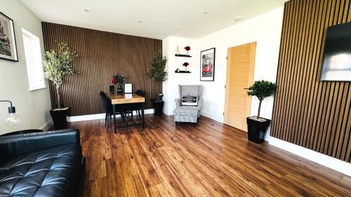 a living room with a black couch and a table at Modern 2 Bedroom Apartment near Crosby Beach & Liverpool in Crosby