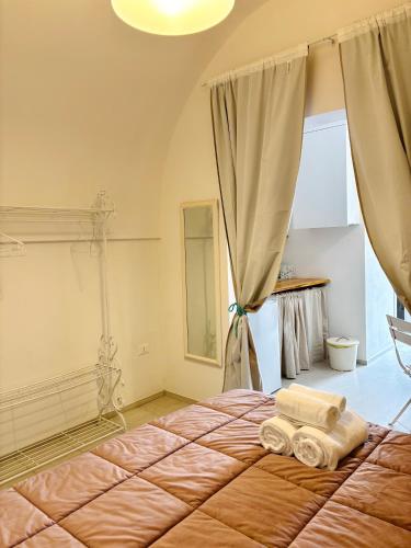a bedroom with a bed with two towels on it at Affittacamere Nalì in Polignano a Mare