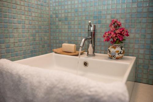 a sink with a faucet and a vase of flowers on it at Lefkada Sunset Villa in Kalamitsi