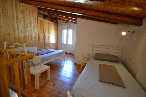 a bedroom with two beds and a wooden floor at Lefkada Sunset Villa in Kalamitsi