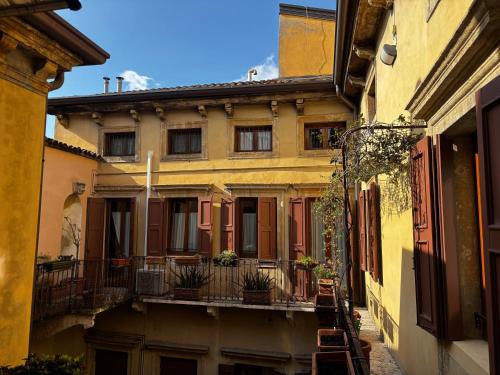an alley in an old building with a balcony at Protezione della Giovane - female hostel in Verona