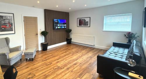 a living room with a couch and wooden floors at Modern 2 Bedroom Apartment near Crosby Beach & Liverpool in Crosby