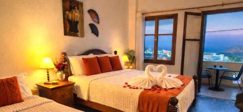 a hotel room with two beds with a heart on it at Knossos Skynest in Palekastron