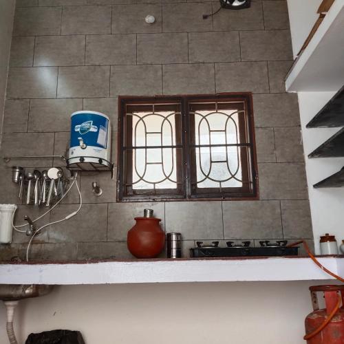 a kitchen with a stove and two windows in it at Natural bliss in Tiruchirappalli