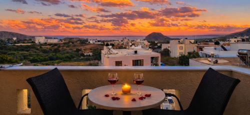 a table with two glasses of wine and a candle at Knossos Skynest in Palekastron