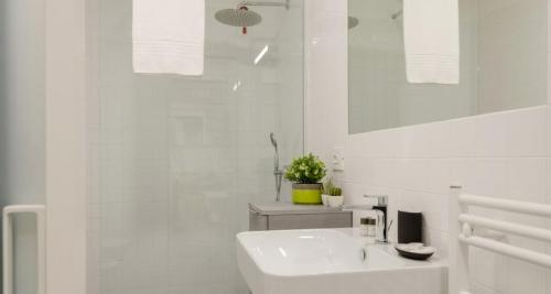 a white bathroom with a sink and a mirror at Modern Apartment between Como & Milan in Lomazzo