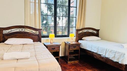 a bedroom with two beds and a window at 1825 Hotel in La Paz