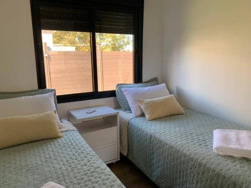 a bedroom with two beds and a window at Casa 6 personas con piscina en Piriápolis Playa los Angeles in Piriápolis