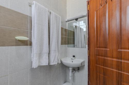 a bathroom with a white sink and a mirror at Wendy's Da-Azizi Homes Diani 2 in Diani Beach