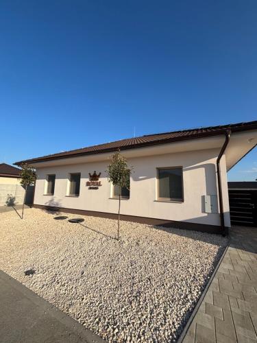a house with a gravel driveway in front of it at ROYAL homes in Nesvady