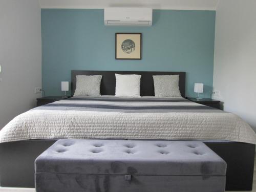 a bedroom with a large bed with a blue wall at ZÁMOR HOLIDAY HOUSE in Keszthely