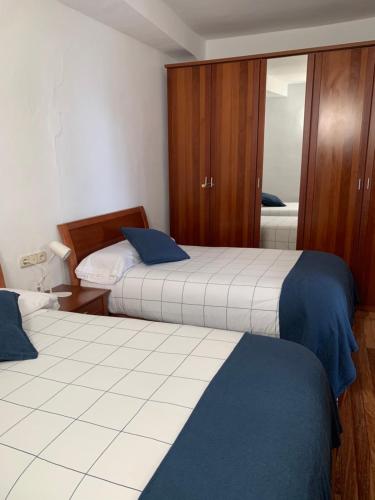 a hotel room with two beds and a mirror at Atxitxin in Mutriku