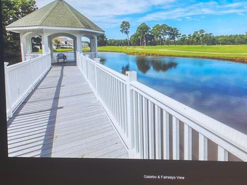 a gazebo on a bridge over a river at First Class Treatment Luxurious end unit Patio Pool Restaurant Bar on premises Steps away from Everything else! Spacious Condo Stocked with all You Need! in Myrtle Beach