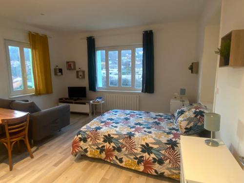 a bedroom with a bed and a living room at Confortable studio meublé classé 3 étoiles in Châtel-Guyon