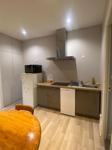 a kitchen with a table and a counter top at Confortable studio meublé classé 3 étoiles in Châtel-Guyon